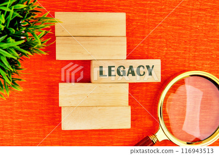 Legacy written on the blocks in a composition with a magnifying glass and a plant. View from above Legacy written on the blocks in a composition with a magnifying glass and a plant. View from above 116943513