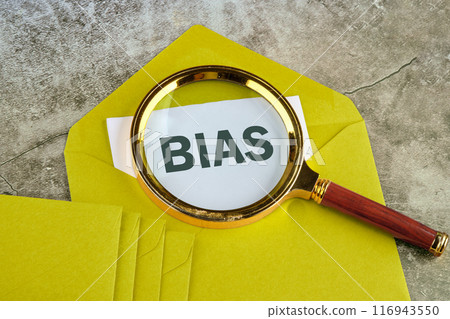 Personal opinions prejudice bias concept. BIAS through a magnifying glass on a piece of mustard-colored envelope Personal opinions prejudice bias concept. BIAS through a magnifying glass on a piece of mustard-colored envelope 116943550