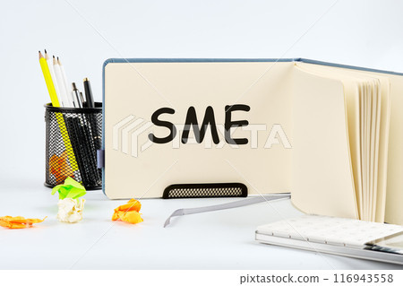 The words SME Small and Medium Size Enterprises written in a notebook on a table on a light background 116943558