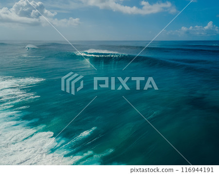 Blue barrel wave in Bali island. Crashing surfing wave. Aerial view 116944191