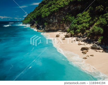Drone view of scenic coastline with turquoise ocean and tropical sandy beach in Bali island. Drone view of scenic coastline with turquoise ocean and tropical sandy beach in Bali island. 116944194