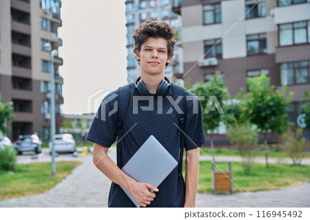 Portrait young male college student with backpack laptop, outdoor urban background Portrait young male college student with backpack laptop, outdoor urban background 116945492