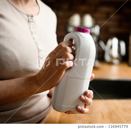 Girl with milk at kitchen at home 116945779