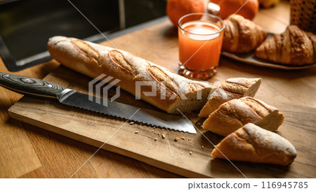 Fresh baguette on a cutting board at the kitchen Fresh baguette on a cutting board at the kitchen 116945785