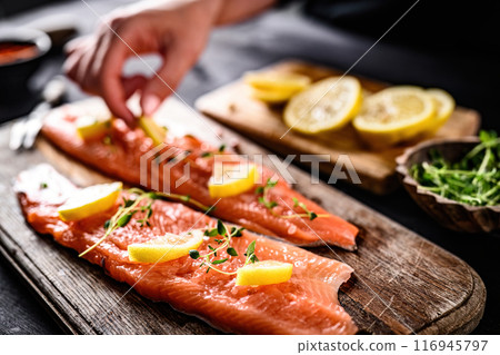 girl cooking fillet trout red fish with lemon girl cooking fillet trout red fish with lemon 116945797