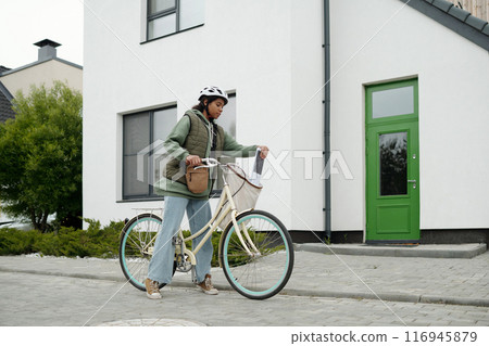 Postwoman taking newspapers out of sack Postwoman taking newspapers out of sack 116945879