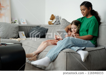 Girls watching online cartoons or movie Girls watching online cartoons or movie 116946033