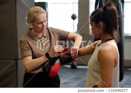 Helping to fix boxing glove on punch Helping to fix boxing glove on punch 116946077
