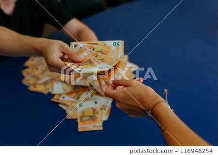 upper view of two person hands passing each other banknotes over the table 116946254