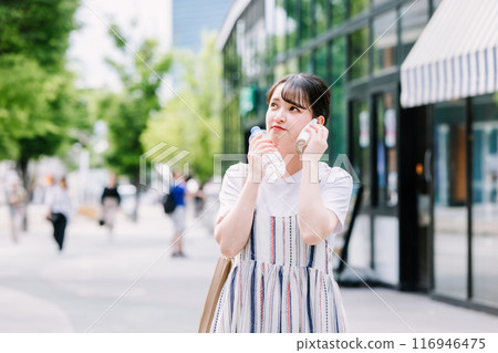 A young woman cools herself down with a plastic bottle during the heatwave A young woman cools herself down with a plastic bottle during the heatwave 116946475
