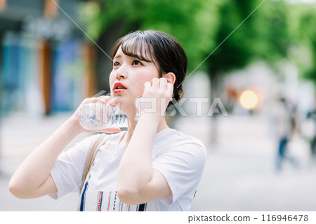 一名年輕女子忍受酷熱，用塑膠瓶為自己降溫 116946478