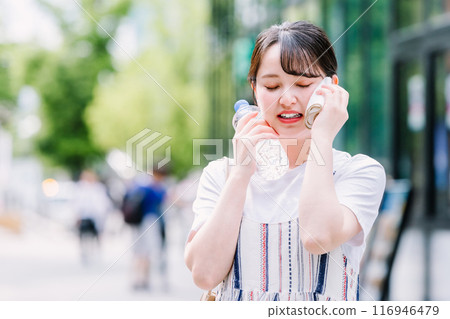 一名年輕女子忍受酷熱,用塑膠瓶為自己降溫 一名年輕女子忍受酷熱,用塑膠瓶為自己降溫 116946479