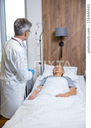Male doctor examining a patient in an intensive therapy department Male doctor examining a patient in an intensive therapy department 116946493