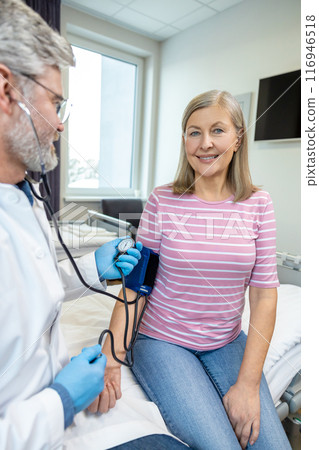 Male gray-haired doctor with a tonometer in hands Male gray-haired doctor with a tonometer in hands 116946518
