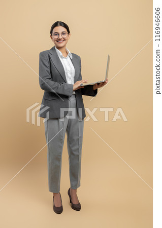 Attractive happy woman in formal wear using laptop for remote work Attractive happy woman in formal wear using laptop for remote work 116946606