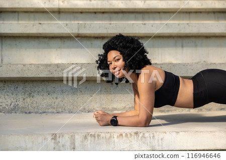 Pretty brunette young woman standing in a plank Pretty brunette young woman standing in a plank 116946646
