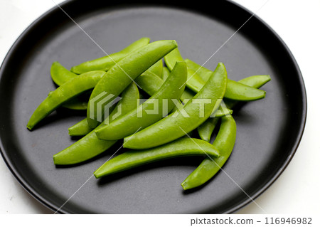 Fresh young green peas on dark plate 116946982