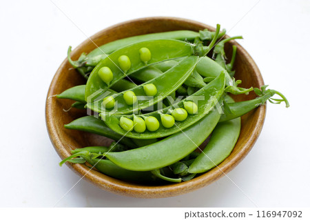 Fresh young green peas on white background. Fresh young green peas on white background. 116947092