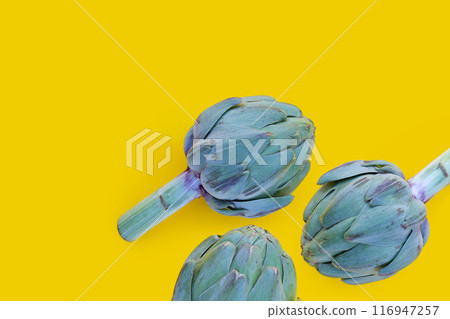 Fresh artichoke on yellow background. Fresh artichoke on yellow background. 116947257