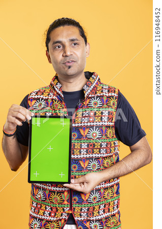 Jolly influencer showing isolated screen tablet for tech fans audience, studio background. Cheerful technology expert showcasing mockup device used for advertising brands Jolly influencer showing isolated screen tablet for tech fans audience, studio background. Cheerful technology expert showcasing mockup device used for advertising brands 116948452