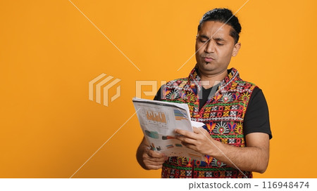 Man browsing though financial audit report files, slapping them in anger, disappointed by results, studio background. Upset indian worker frowning, annoyed by paperwork, camera A Man browsing though financial audit report files, slapping them in anger, disappointed by results, studio background. Upset indian worker frowning, annoyed by paperwork, camera A 116948474