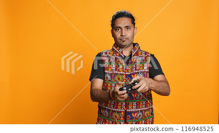 Upset man showing thumbs down sign gesturing holding controller, disapproving of videogames. Displeased indian person against gaming, doing rejection hand gesture, studio background, camera B Upset man showing thumbs down sign gesturing holding controller, disapproving of videogames. Displeased indian person against gaming, doing rejection hand gesture, studio background, camera B 116948525