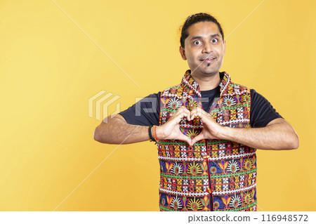 Portrait of jolly friendly man doing heart symbol shape gesture with hands. Cheerful nurturing person showing love gesturing, being appreciative, isolated over studio background Portrait of jolly friendly man doing heart symbol shape gesture with hands. Cheerful nurturing person showing love gesturing, being appreciative, isolated over studio background 116948572