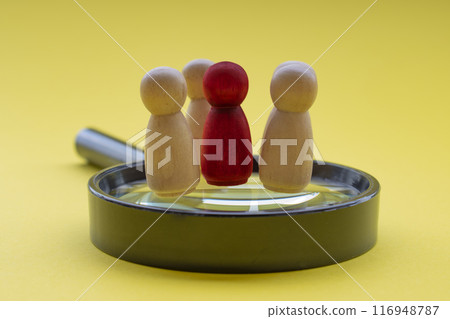 A red wooden figure with his or her team member standing on top of a magnifying glass. Leadership and business concept A red wooden figure with his or her team member standing on top of a magnifying glass. Leadership and business concept 116948787