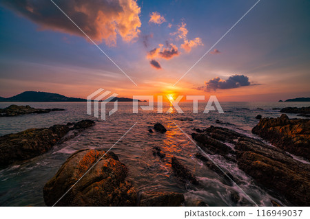 Long exposure image of Dramatic sky seascape with rocks and waves crashing on seashore in sunset or sunrise scenery background Long exposure image of Dramatic sky seascape with rocks and waves crashing on seashore in sunset or sunrise scenery background 116949037