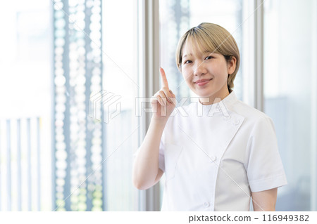 A young female chiropractor with short blonde hair wearing a Casey white coat (free hair color, work in your own way, work environment) A young female chiropractor with short blonde hair wearing a Casey white coat (free hair color, work in your own way, work environment) 116949382