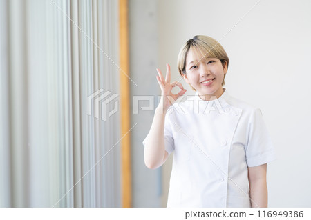 Casey 一位年輕的女性脊椎按摩師，金髮短髮，穿著白色外套（頭髮顏色自由，按自己的方式工作，工作環境） 116949386