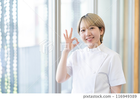 A young female chiropractor with short blonde hair wearing a Casey white coat (free hair color, work in your own way, work environment) A young female chiropractor with short blonde hair wearing a Casey white coat (free hair color, work in your own way, work environment) 116949389