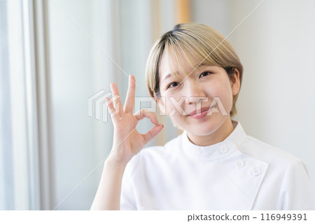 A young female chiropractor with short blonde hair wearing a Casey white coat (free hair color, work in your own way, work environment) A young female chiropractor with short blonde hair wearing a Casey white coat (free hair color, work in your own way, work environment) 116949391