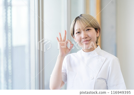 Casey 一位年輕的女性脊椎按摩師，金髮短髮，穿著白色外套（頭髮顏色自由，按自己的方式工作，工作環境） 116949395