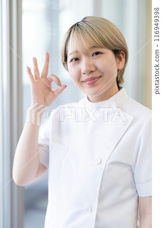 A young female chiropractor with short blonde hair wearing a Casey white coat (free hair color, work in your own way, work environment) A young female chiropractor with short blonde hair wearing a Casey white coat (free hair color, work in your own way, work environment) 116949398