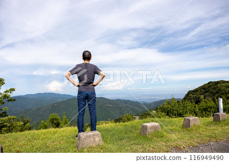 一名男子攀登伊吹山,雙手叉腰看風景 一名男子攀登伊吹山,雙手叉腰看風景 116949490
