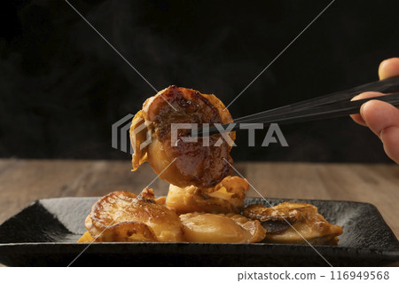Scallops grilled with butter, chopsticks raised 116949568