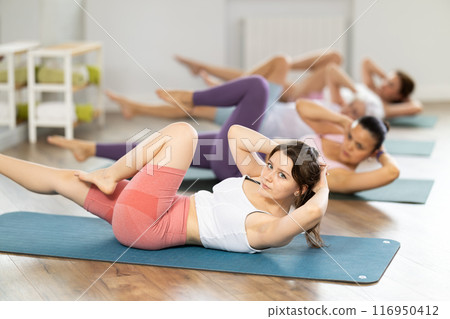 Young woman doing pilates in group Young woman doing pilates in group 116950412