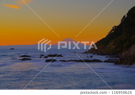 Mount Fuji seen across the sea from Namayazaki in Minamiboso with the crimson sunset sky as a backdrop Ver5 116950628