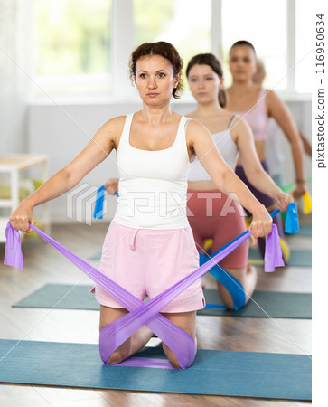 Adult woman exercising with pilates band 116950634