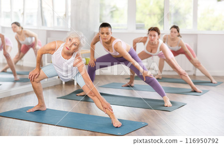 Elderly woman doing pilates in group Elderly woman doing pilates in group 116950792