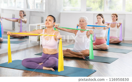 Young woman exercising with pilates band Young woman exercising with pilates band 116950830