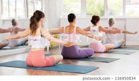 Rear view of group of women exercising with figure eight exercise bands 116950834