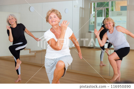 Active elderly lady learning modern dynamic dances in choreography class 116950890