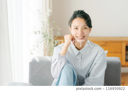 一位 30 多歲的女性在客廳放鬆 一位 30 多歲的女性在客廳放鬆 116950922