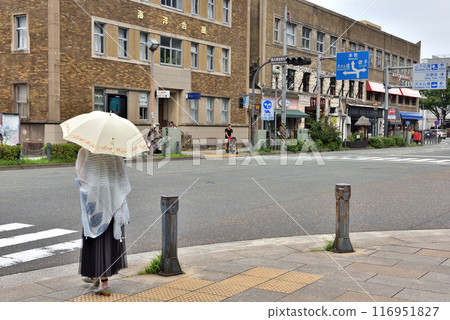 A woman holding a parasol waiting for the traffic light at the Yokohama Japan Boulevard Port Opening Museum intersection 116951827