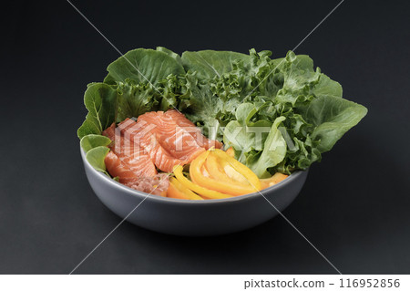 Vegetable salad with fresh salmon in salad bowl on black background 116952856