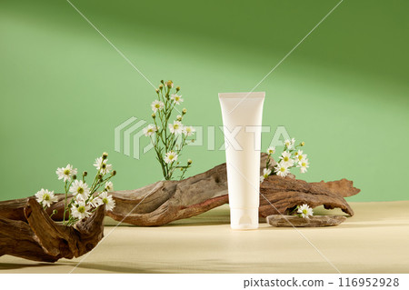 Template photo for promote natural cosmetic products with an unlabeled cosmetic tube displayed in front of a log, dotted by some tiny tanacetum flowers. Frontal shot, empty space for text Template photo for promote natural cosmetic products with an unlabeled cosmetic tube displayed in front of a log, dotted by some tiny tanacetum flowers. Frontal shot, empty space for text 116952928