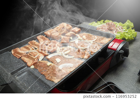 A red grill with meat and onions on it A red grill with meat and onions on it 116953252