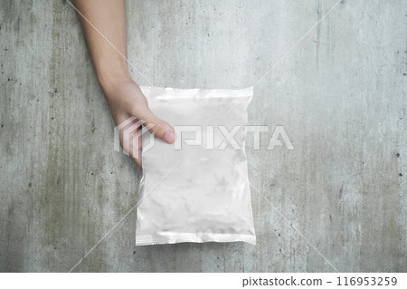 A person is holding a bag of instant noodle that is wrapped in foil A person is holding a bag of instant noodle that is wrapped in foil 116953259